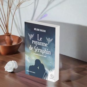 Le roman le royaume de Séraphin (tome 1 adultes) sur une table avec une rose blanche à côté
